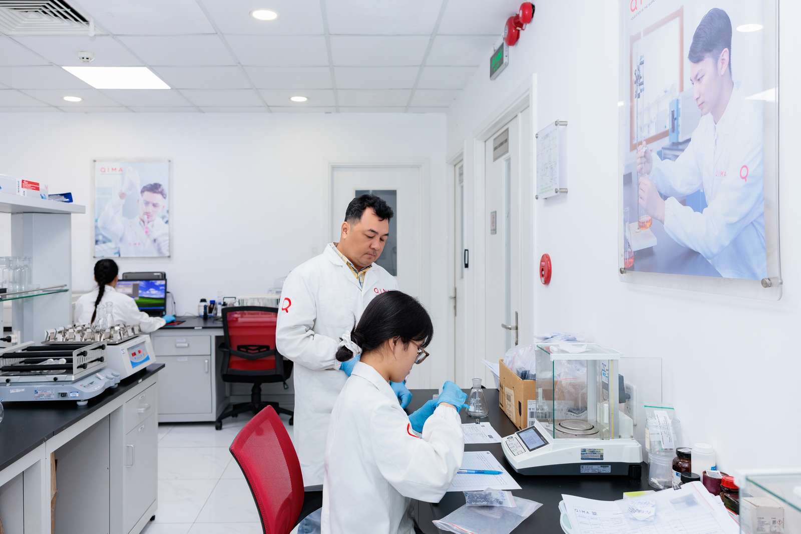 QIMA lab technicians perform chemical and physical testing at an accredited laboratory, supporting compliance programs for consumer products across global markets.